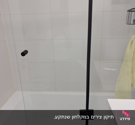 מקלחון עם דלת זכוכית ומסגרת שחורה